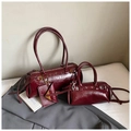 Détail de deux sacs cylindriques bordeaux avec une texture de cuir verni froissé - Grand / Rouge