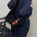 Minimalist black crescent hobo bag with ethnic pompom charm worn with a stylish trench coat - Black with Pendant