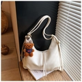 Dettaglio della borsa hobo crema con zip e ciondolo a forma di orsetto marrone - Bianco con ciondolo