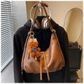 Dettaglio della borsa hobo in pelle marrone vintage con un tenero ciondolo a orsetto - Marrone con ciondolo