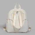 Detail view of cream nylon backpack featuring dual metal zippers and side drawstring pockets - White