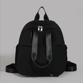 Detailed close-up of durable black nylon fabric, ergonomic straps and silver zipper on backpack - Black
