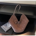 Dettaglio della borsa tote in pelle scamosciata marrone con apertura a V e ciondolo - caffè