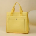 Dettaglio della borsa tote in tela gialla con tasca frontale e bottone in metallo argento - Giallo