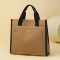 Detail showing high-capacity khaki canvas tote bag with black strap accents and snap pocket - Brown