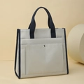 Dettaglio della borsa in tela con manici blu scuro e tasca anteriore con bottone in metallo - Blu grigio