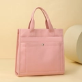 Vista dettagliata della borsa tote in tela rosa con tasca a scatto e manici resistenti - Rosa