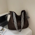 Borsa tote chic leopardata con tracolla a righe in un ambiente minimalista - Verde