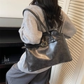 Bolso tote grande negro vintage con detalles de hebillas llevado al hombro por modelo - Negro