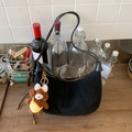 Detail der schwarzen Wildleder-Hobo-Tasche mit Lederbesatz und süßem Plüschbär-Anhänger - Schwarz mit Anhänger
