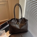 Bolso tote de cuero marrón oscuro con hebilla dorada en una oficina moderna - Marrón