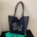 Dettaglio del ricamo a bassotto su una borsa tote in tela blu con motivi a quadretti - Blu