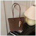 Detalle del bolso tote marrón mate vintage con colgante de cuentas y anillos dorados - Marrón