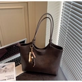 Detalle de bolso tote de cuero marrón oscuro con asa anudada y borlas de cuentas - Con Colgante / café
