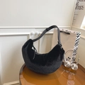 Fuzzy black plush hobo bag with adjustable leather strap on a stylish table - Black