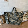 Detail der grünen Camouflage-Canvas-Tasche mit verstellbarem Gurt auf rustikalem Holztisch - Grün
