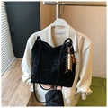 Dettaglio della borsa tote in pelle scamosciata leopardata con ciondolo in legno - Nero