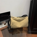 Bolso bandolera de nailon caqui con correa negra ancha en mesa de oficina de cristal - Caqui
