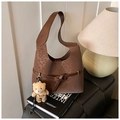 Detailed view of brown leopard print bucket bag with metal buckle and teddy bear charm - With Charm / Brown