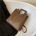 Braune matte Leder-Einkaufstasche mit quadratischem Hohlgriff auf schwarzem Blazer - Dunkelbraun