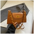 Dettaglio borsa vintage in pelle marrone con catena dorata e chiusura a girello in metallo - Marrone