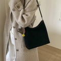 Grand sac cabas en daim noir avec breloques cœur porté avec un manteau en laine beige - Noir avec pendentif