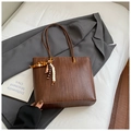 Detailed view of brown woven tote bag with colorful beaded tassel and gold hardware - Brown with Pendant