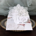 Macro detail of laser-cut wedding invitation featuring 3D Mr & Mrs silhouette and flowers - White
