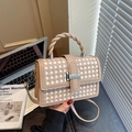 Beige woven handbag with twist handle and metal clasp in a modern office setting - Khaki
