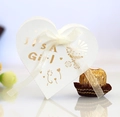 Detail of white heart favor box with gold It's a Girl text and a white silk ribbon - Ivory