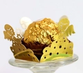 Macro detail of laser-cut gold angel hollow paper wrappers for chocolate decorations - Reflective Gold
