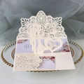 Detailed laser-cut ivory wedding invitation with floral insert on a gold-rimmed glass tray - Ivory