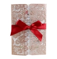 Detail of rose gold laser cut lace wedding invitation with a red satin bow accent - Glitter Champagne Gold