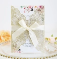 Elegante goldene lasergeschnittene Hochzeitseinladung mit weißer Schleife und Blumen - Hellgold Glitzer
