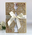 Detail of laser cut wedding invitation with cream satin bow and gold floral inner card - Beige Gold