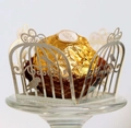 Detail of silver laser-cut birdcage pattern wrapper around a chocolate truffle - Reflective Silver
