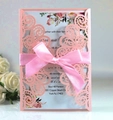Détail d'invitation de mariage rose découpée au laser avec ruban satin et carte fleurie - Rose