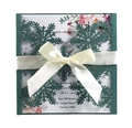 Detail of laser-cut green snowflake invitation with a cream bow and floral inner card - Ink Green