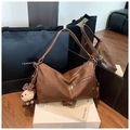 Détail d'un sac hobo marron vintage avec fermetures éclair et un charme d'ours - Marron avec pendentif