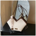 Dettaglio della trama del tessuto chevron e finiture in pelle marrone sulla borsa tote - Bianco crema con marrone