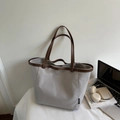 Bolso tote de lona gris claro con asas de cuero marrón y etiqueta de marca elegante - Gris