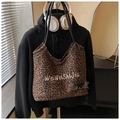 Dettaglio della borsa tote leopardata con ricamo bianco e sottili manici in pelle nera - Taglia unica / caffè