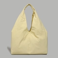 Detailed close-up of cream yellow nylon tote bag with minimalist seamless handle - Yellow