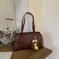 Detail of vintage dark brown leather tote with metallic logo and cute teddy bear charm - Red with Pendant