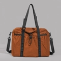 Vorderansicht der karamellfarbenen Reisetasche aus Nylon mit Kordelzugtasche vorne - Orange
