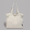 Detail of off-white tote bag showing textured fabric, drawstring side and metal snap button - White