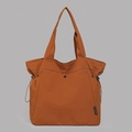 Detailansicht der großen Nylon-Einkaufstasche mit seitlichen Kordelzügen und Textur - Orange