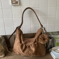 Detalle de un bolso hobo de gamuza marrón con bolsillo frontal de cordón y adorno de dona - Con Colgante / Marrón