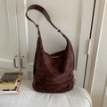 Dark brown suede hobo bag with adjustable leather strap on a textured white cushion - Coffee without Pendant