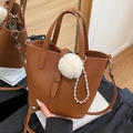 Braune Beuteltasche mit Litschi-Maserung, Plüschpompon, Perlenanhänger und Schultergurt - Braun mit Anhänger